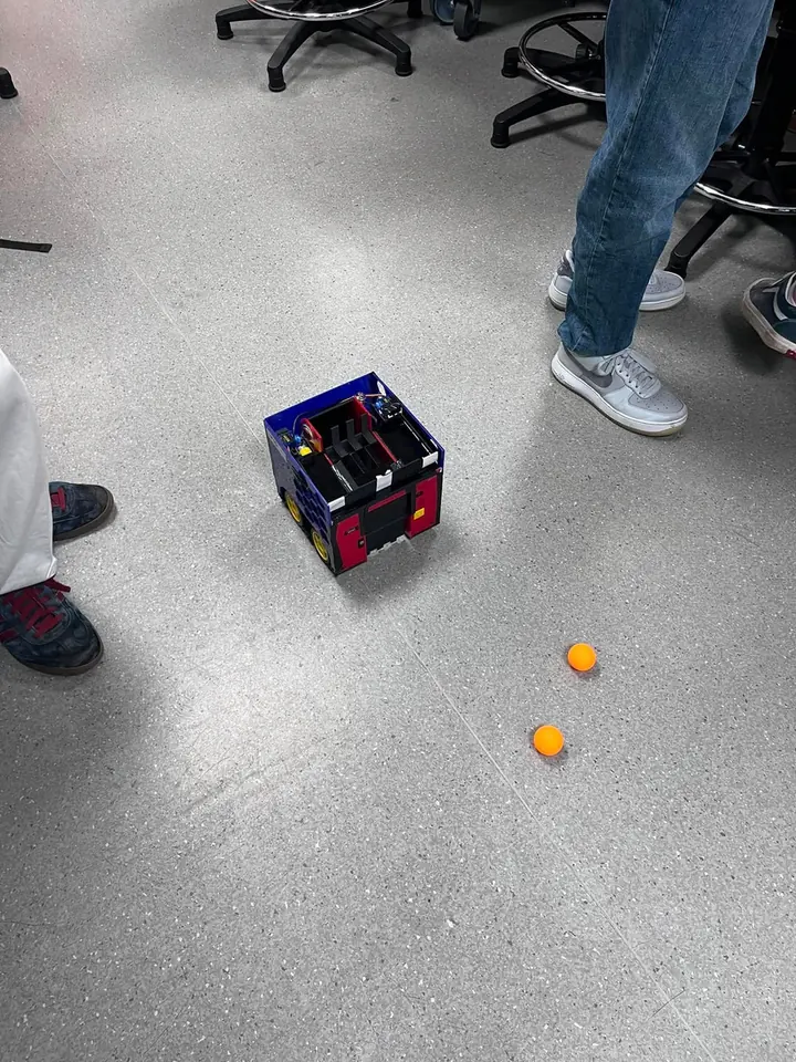 The robot being tested on the floor with ping pong balls